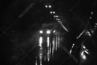 Rain at night on the road with street lights in the dark street