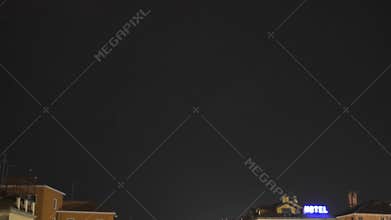 Rainstorm in city, lightning bolts flicker over rooftops, rain and thunder sound