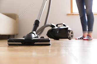 People, housework and housekeeping concept - happy woman with vacuum cleaner at home. Spring cleaning