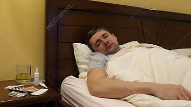 A sick young man in a bed.