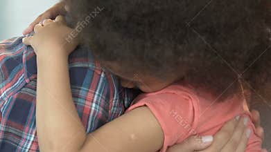 Mother calming down adopted daughter, trusting female relationships, hugging