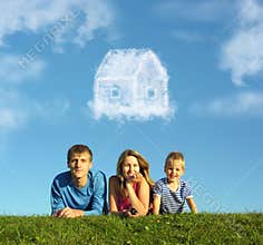 Family with boy on grass and dream cloud house