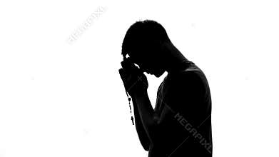 Religious man with rosary in hands praying on white background, spiritual ritual