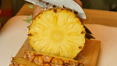 The hands of the women are using knife sliced a pineapple