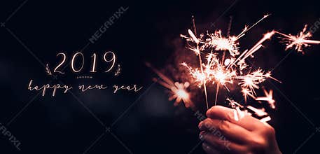 Hand holding burning Sparkler blast with happy new year 2019 on