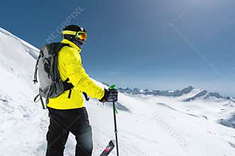 Portrait of a professional freerider skier standing on a snowy slope against the background of snow-capped mountains
