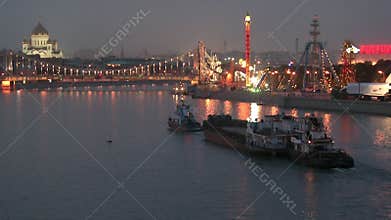 Barges are floating along the river in evening.