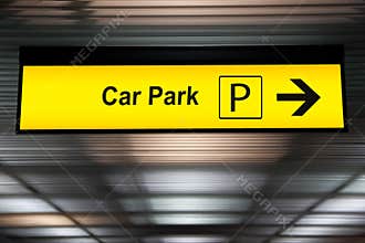 Yellow car park sign with arrow pointing to car parking zone