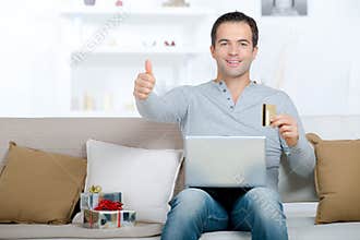 Happy man in house buying online