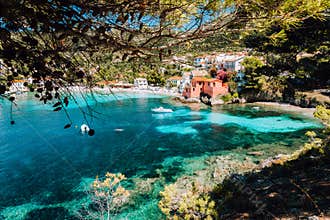 Lovely bay of assos village, Kefalonia, Greece. View on tourquise transparent water framed between green pine grove