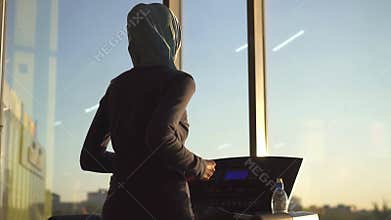 Young muslim girl in hijab doing sports on the treadmill.Slow mo