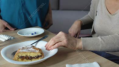 Woman refusing to eat pie, nurse trying to persuade, old age digestion problem