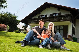 Family sitting in front of their home