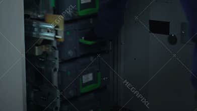 Bank employee checking ATM safe, taking out case with euros in cash, banking