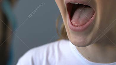 Medical specialist examining girl throat by tongue depressor, cold virus, cough