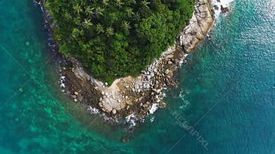 Overhead drone shot of tops of palm trees and turquoise sea water in Ko Pu island in Phuket, Thailand. Abstract texture, place for
