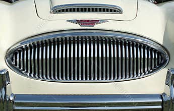Close up of the chrome grill bumper and badge of a vintage white austin healey 300 classic sports car at hebden bridge vintage wee