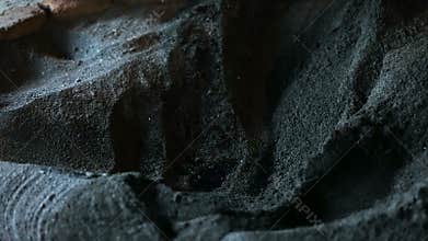 Hand of male archaeologist carefully removing ashes in search of artifacts