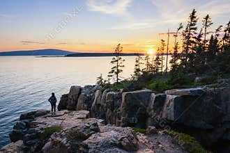 A hiker enjoying the sunset at Schoodic Point Maine