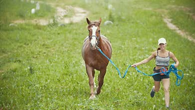 Woman running on the field with a horse