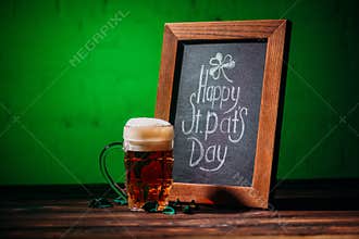 wooden frame with happy st patricks day inscription and glass of beer