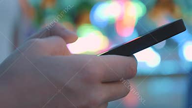 Close-up of a hand typing sms on a smartphone. Online surfing in social networks. Communicate with friends using your