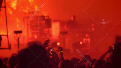 Crowd cheering and applauding at rock concert during nighttime