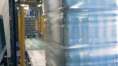 Packaged set of plastic beer bottles is getting removed by a transporter
