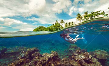 Split underwater photo of a girl snorkeling with mask in tropical ocean enjoying summer vacation on exotic island