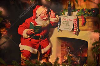 Vintage painting of Santa Claus by fireplace in International Drive area.