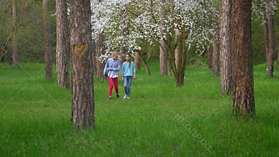 Two appealing little Teen girlfriend walk in Park, teenage female friends having fun smiling with guitar in hand