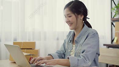 Beautiful smart Asian young entrepreneur business woman owner of SME online checking product on stock and save to computer working