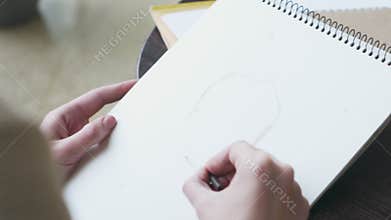 Artist sketching model face using crayon at cafe