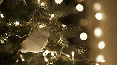 Female decorating Christmas tree with bird toy