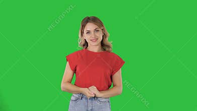 Happy young woman showing a product pointing with her finger to sides Presentation on a Green Screen, Chroma Key.