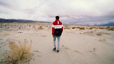 Lonely man walking on desert road
