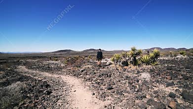 Lonely man walking on desert road