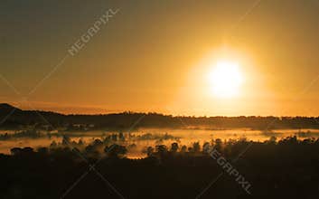 Golden glow of morning over mist in winter