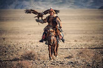 Bayan-Ulgii, Western Mongolia - October 07, 2018: Golden Eagle Festival. Sunny Day And Mongolian Nomad-Hunter With Great Golden