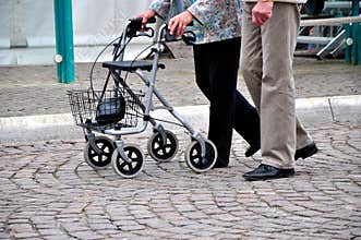 Old couple pushing rollator