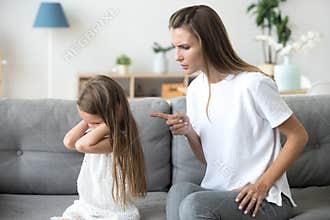 Angry mother scolding stubborn kid closing ears not listening