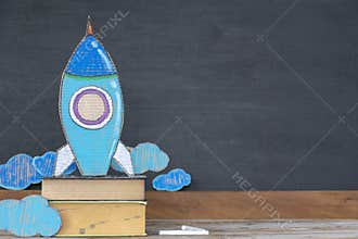 Back to school concept. Paper rockets are located on books
