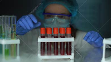 Researcher taking tubes with blood serum from fridge, stem cells analysis