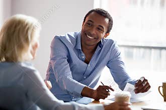 Smiling african american manager talking with client at business meeting
