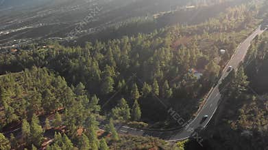 Aerial shot. Flight over a new asphalt mountain road on which cars are moving. New road markings. hairpin turn