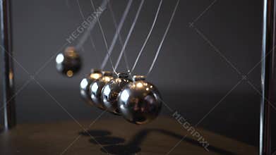 Closeup video of metal Newton cradle swining on gray background