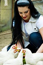Smiling woman feeding poultry