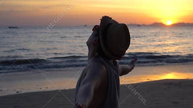 Young man with outstretched arms near sea