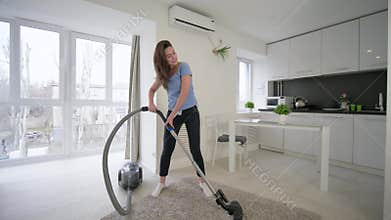 Fun home cleaning, attractive housewife woman doing cleaning vacuums and cheerful dancing and sings in room at home