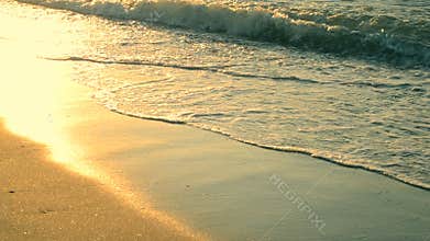 Sunny path glitters on the wet sand on the seashore